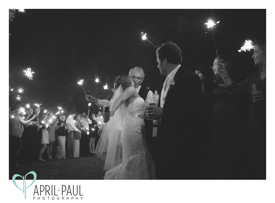 Bride kissing her father during sparkler exit at The Old Place in Gautier, Ms