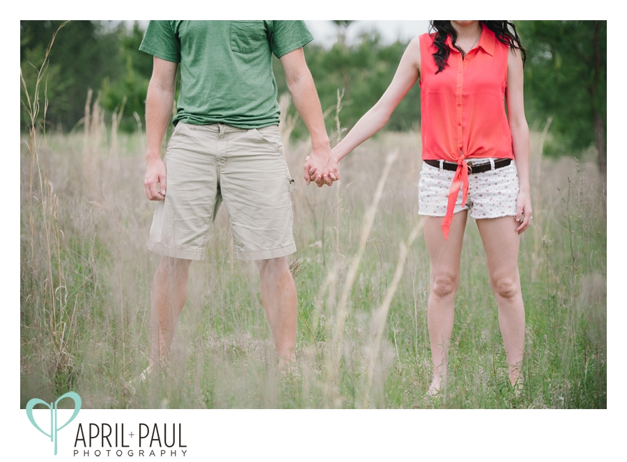 Couple holding hands in a field in Hattiesburg, MS