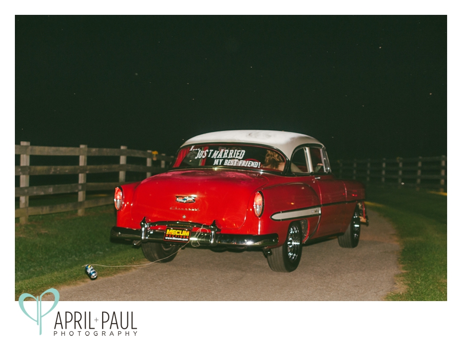 Bride and Groom leaving in antique red car with just married 